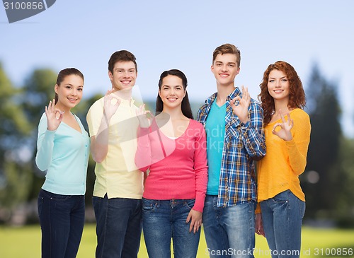 Image of group of smiling teenagers over green park