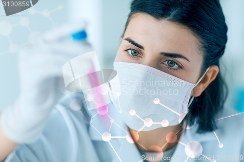 Image of close up of scientist with tube making test in lab