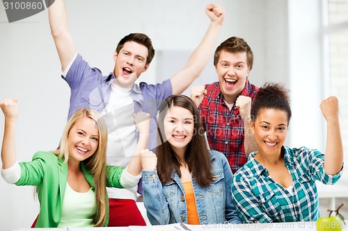 Image of students holding hands up at school