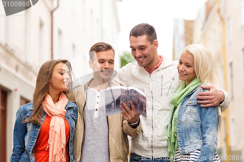 Image of group of friends with city guide exploring town