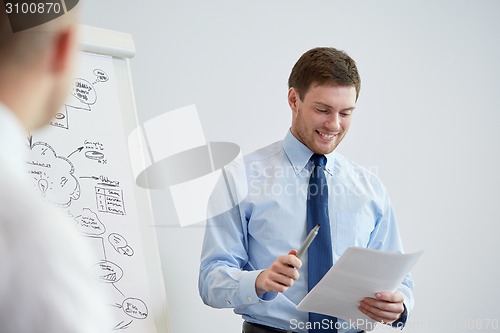 Image of group of smiling businessmen meeting in office