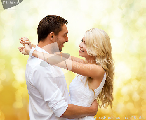 Image of happy couple hugging over yellow lights background