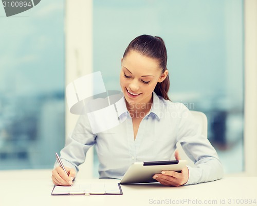 Image of businesswoman with tablet pc and files in office