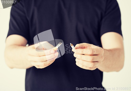 Image of man breaking the cigarette with hands