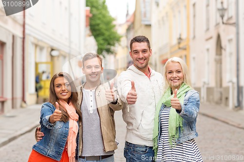 Image of group of smiling friends showing thumbs up