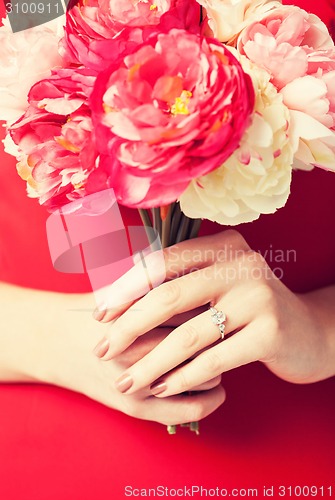 Image of woman hands with flowers and ring