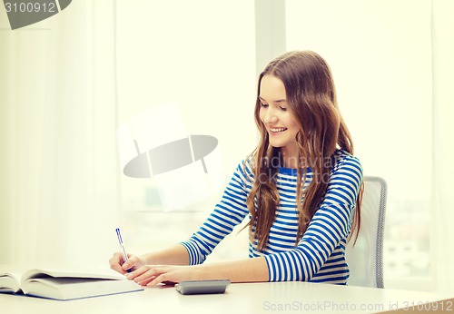 Image of student girl with book, calculator and notebook