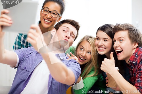 Image of students taking selfie with tablet pc at school