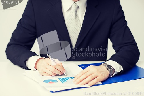 Image of businessman working and signing papers