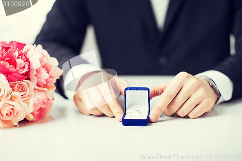 Image of man with gift box and wedding ring