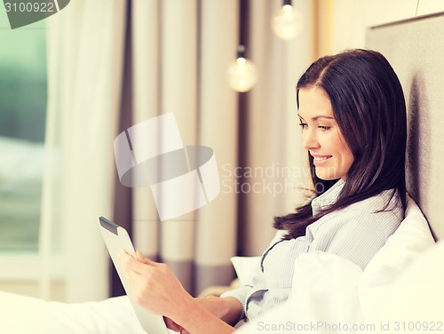 Image of happy businesswoman with tablet pc in hotel room