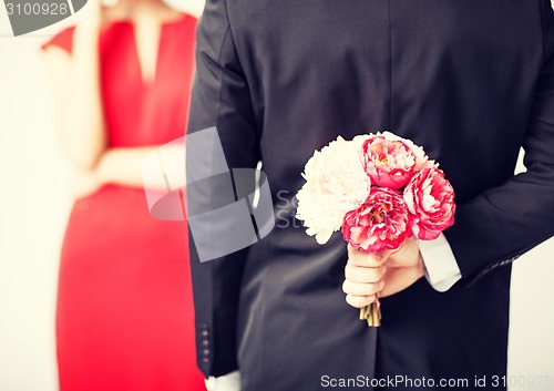 Image of man hiding bouquet of flowers