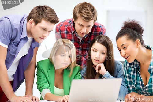 Image of international students looking at laptop at school