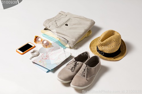 Image of close up of summer clothes and travel map on table