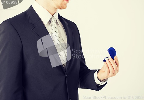 Image of man with gift box and wedding ring