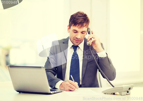 Image of businessman with laptop computer and phone