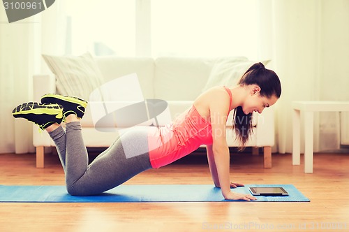 Image of smiling teenage girl doing push-ups at home