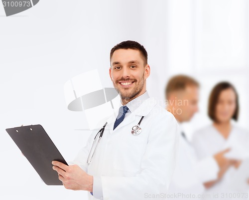 Image of smiling male doctor with clipboard and stethoscope