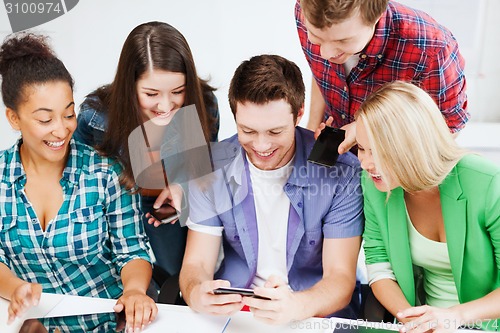 Image of students looking into smartphone at school