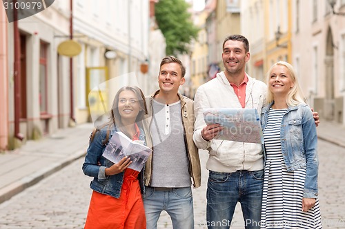 Image of group of smiling friends with city guide and map