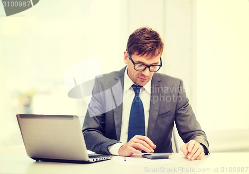 Image of businessman with computer, papers and calculator