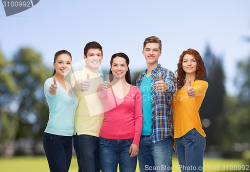Image of group of smiling teenagers over green park