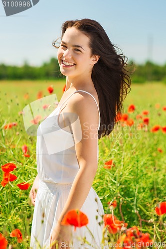 Image of smiling young woman on poppy field