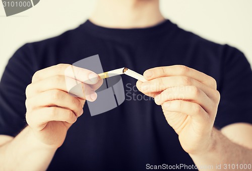 Image of man breaking the cigarette with hands