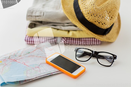 Image of close up of summer clothes and travel map on table