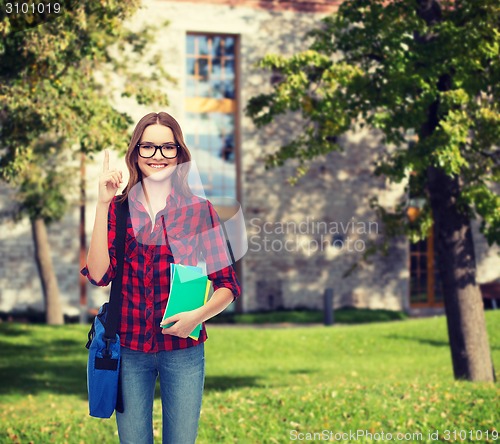 Image of smiling female student with bag and notebooks