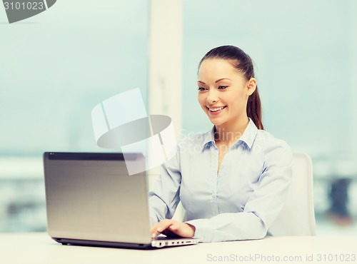 Image of businesswoman with laptop in office