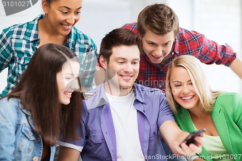 Image of students looking into smartphone at school