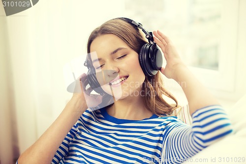 Image of smiling young girl in headphones at home