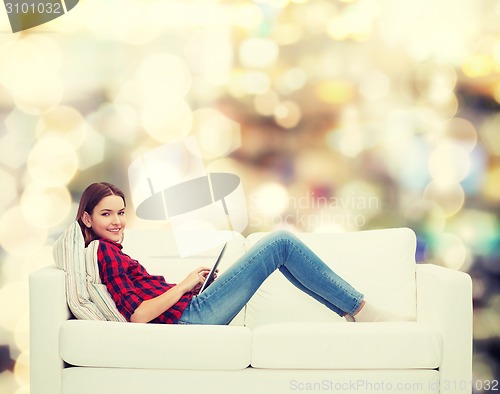 Image of teenage girl sitting on sofa with tablet pc