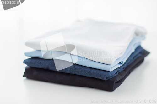Image of close up of ironed and folded t-shirts on table