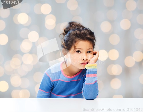 Image of sad little girl over city background