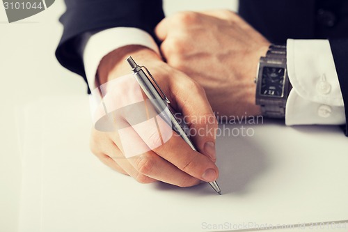 Image of businessman writing something on the paper