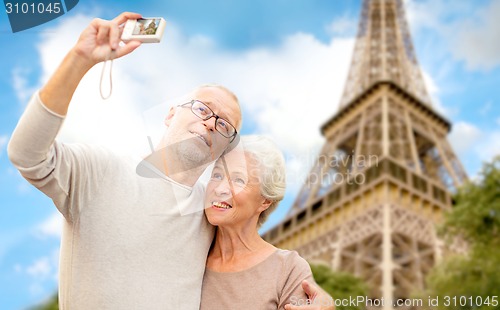Image of senior couple with camera over eiffel tower