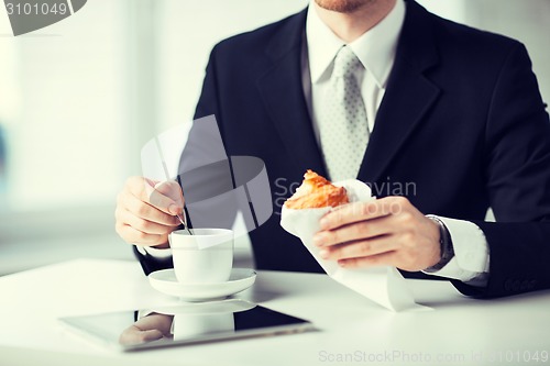 Image of man with tablet pc and cup of coffee