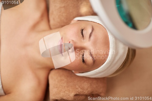 Image of close up of young woman lying in spa