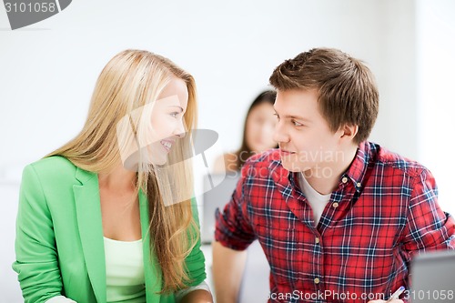 Image of smiling students looking at each other at school