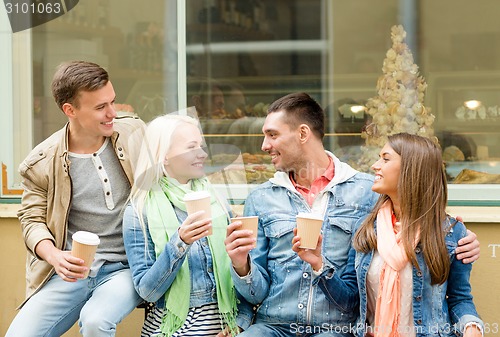 Image of group of smiling friends with take away coffee