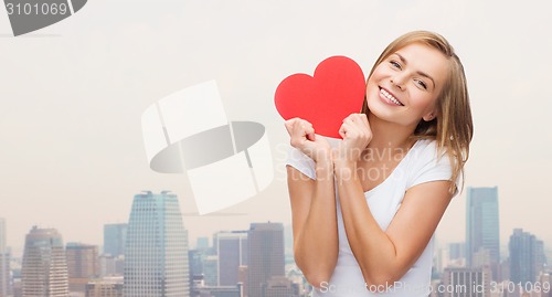 Image of smiling woman in white t-shirt holding red heart