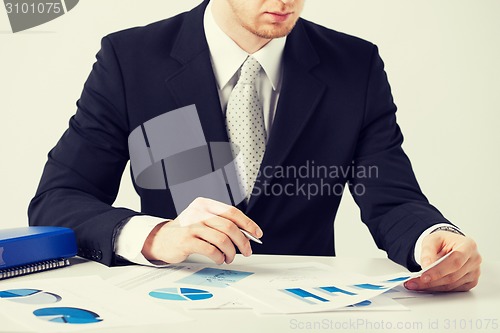 Image of businessman working and signing with papers
