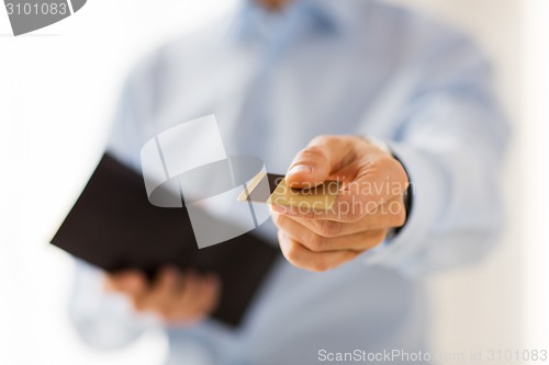 Image of close up of man holding wallet and credit card