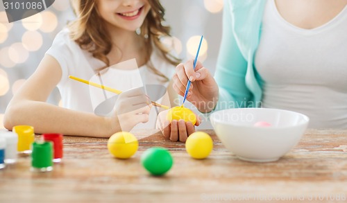 Image of close up of family coloring easter eggs