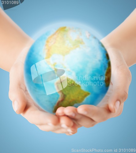 Image of close up of human hands with earth globe