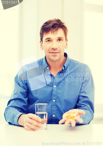 Image of man at home showing lot of pills
