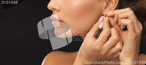 Image of woman wearing shiny diamond earrings