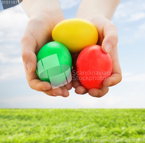 Image of close up of kid hands holding colored eggs